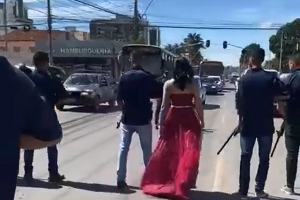Homens armados param trânsito para ‘dama de vermelho’ atravessar rua e vídeo repercute nas redes sociais; vídeo